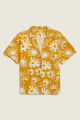 The Mila Cropped Shirt / Solar Bloom by Bridge & Burn is a short-sleeved, button-up mustard yellow shirt with a white abstract starburst print, crafted from organic cotton for a relaxed fit and effortless comfort.