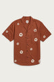 The Collins Slim Shirt by Bridge & Burn features short sleeves, a button-up front, camp collar, and chest pocket. Made from summerweight cotton, it showcases the Redstone Bloom print with scattered white and yellow florals.