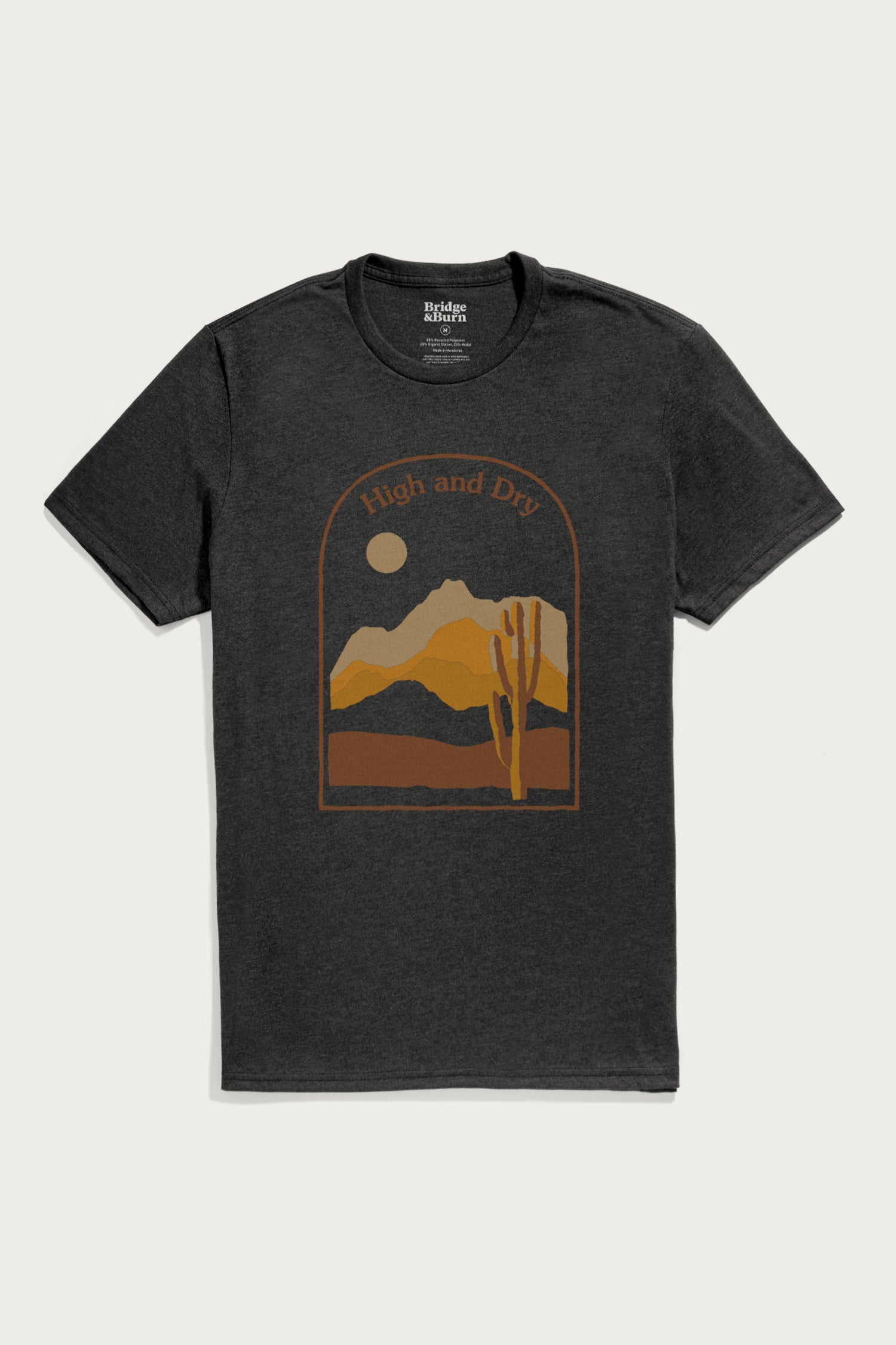 The Bridge & Burn Men's High & Dry Tee in black is a lightweight shirt featuring a desert mountain, cactus, and sun or moon graphic with "High and Dry" above the design.