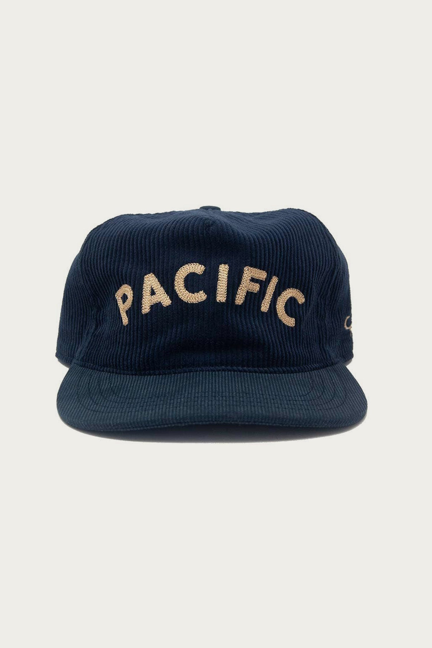 The Ampal Creative - Pacific III Strapback in navy features vintage-style beige "PACIFIC" embroidery on the front, captured against a plain light background.