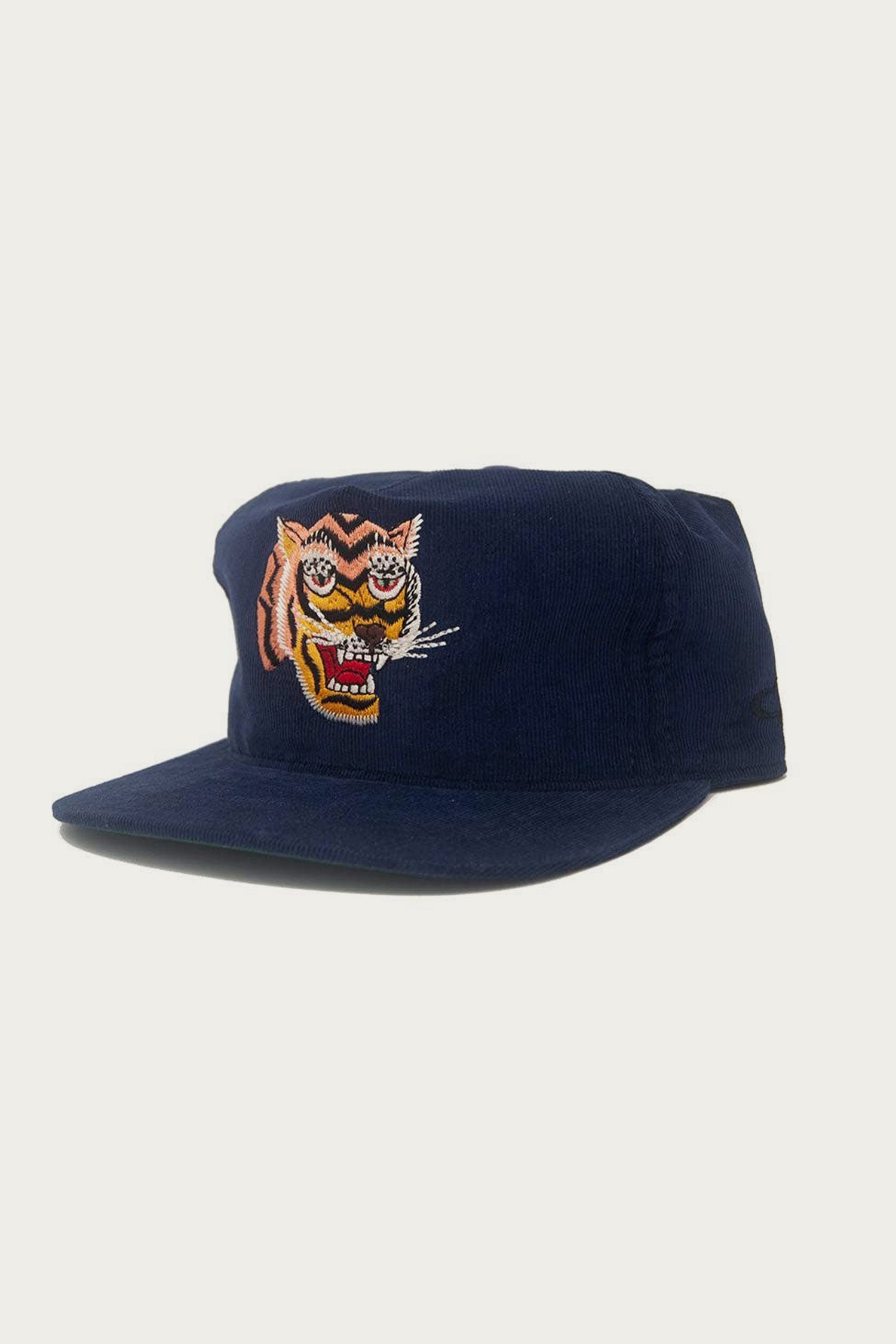 The Ampal Creative - Tiger III Snapback / Navy is a navy blue corduroy cap with an embroidered tiger face on the front, inspired by Vietnam era Souvenir Jacket designs, shown against a plain white background.