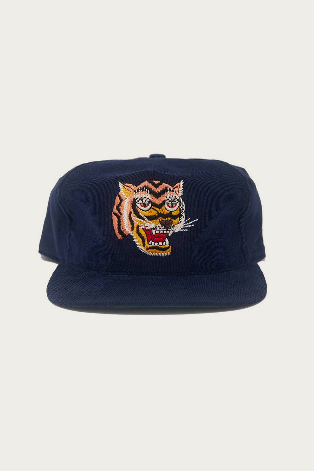 The Ampal Creative - Tiger III Snapback / Navy features a navy blue corduroy cap with a vibrant embroidered tiger face, inspired by Vietnam era Souvenir Jacket art, shown against a plain white background.