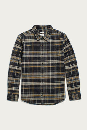 The Bridge & Burn Larson Shirt in Volcanic Plaid is a long-sleeve, button-up flannel with black, gray, and beige tones, a single chest pocket, and pointed collar. Made from recycled cotton. Laid flat on a white background.