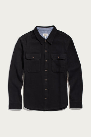 The Bridge & Burn Pointer Overshirt in Ink Stone is a long-sleeve black twill overshirt, featuring two chest pockets and a pointed collar. Crafted from recycled fibers and photographed laid flat on a plain white background, this piece offers a stylish and sustainable choice for your wardrobe.