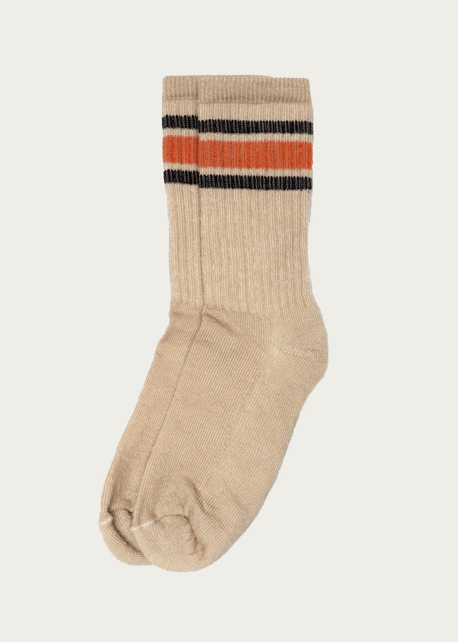 A single American Trench - Merino Activity Crew sock in tan, featuring two black stripes and one orange stripe near the top, is displayed on a plain white background.