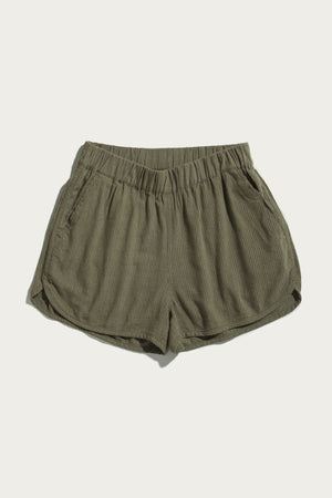 The Bridge & Burn Luca Track Short in Olive Pinstripe features a ribbed fabric, elastic waistband, and side pockets, shown laid flat on a plain white background.