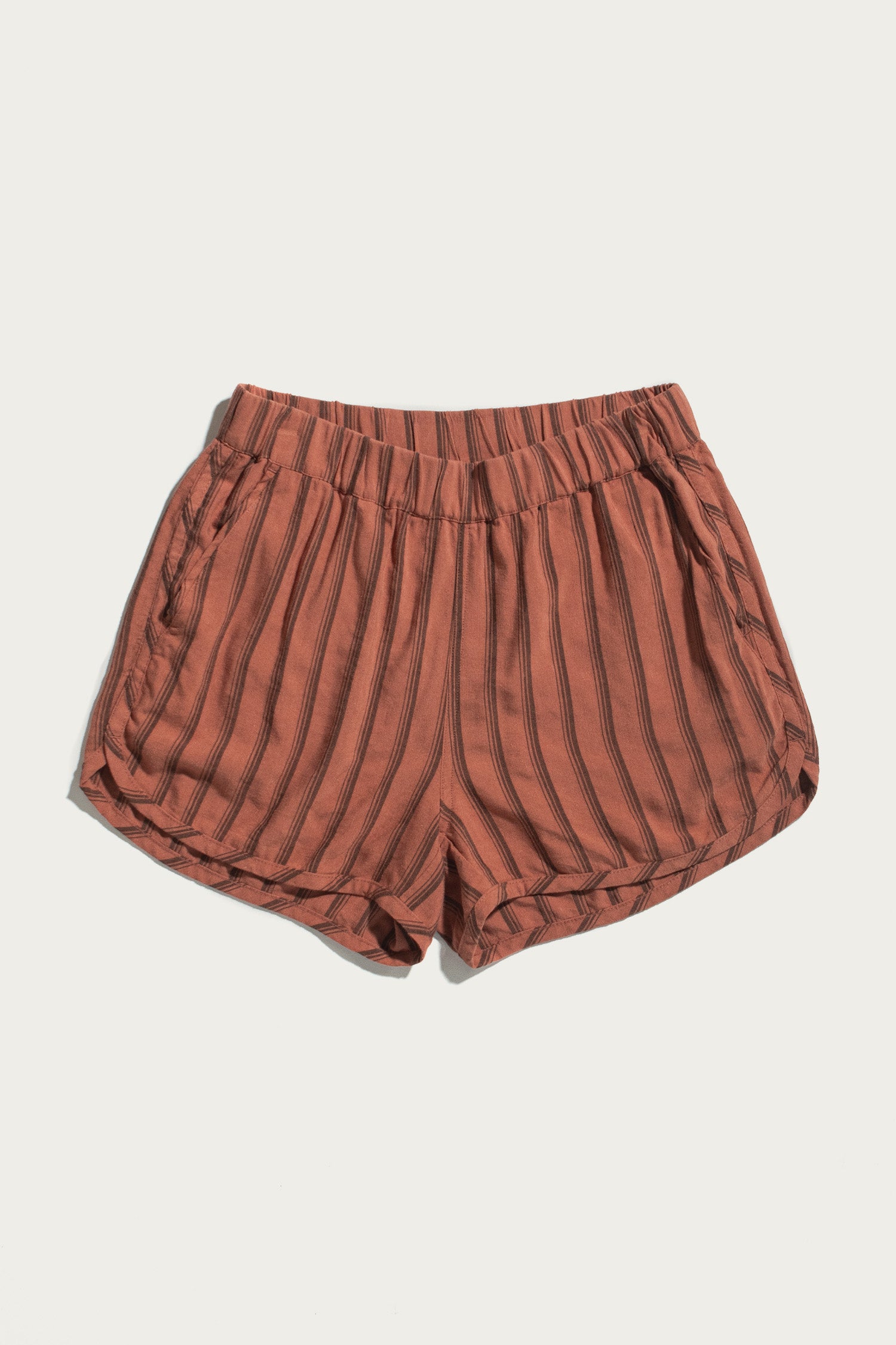 The Luca Track Short in Rust Stripe by Bridge & Burn features vertical black pinstripes, an elastic waistband, and side pockets, shown against a plain white background.