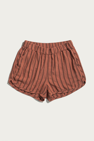 The Luca Track Short in Rust Stripe by Bridge & Burn features vertical black pinstripes, an elastic waistband, and side pockets, shown against a plain white background.