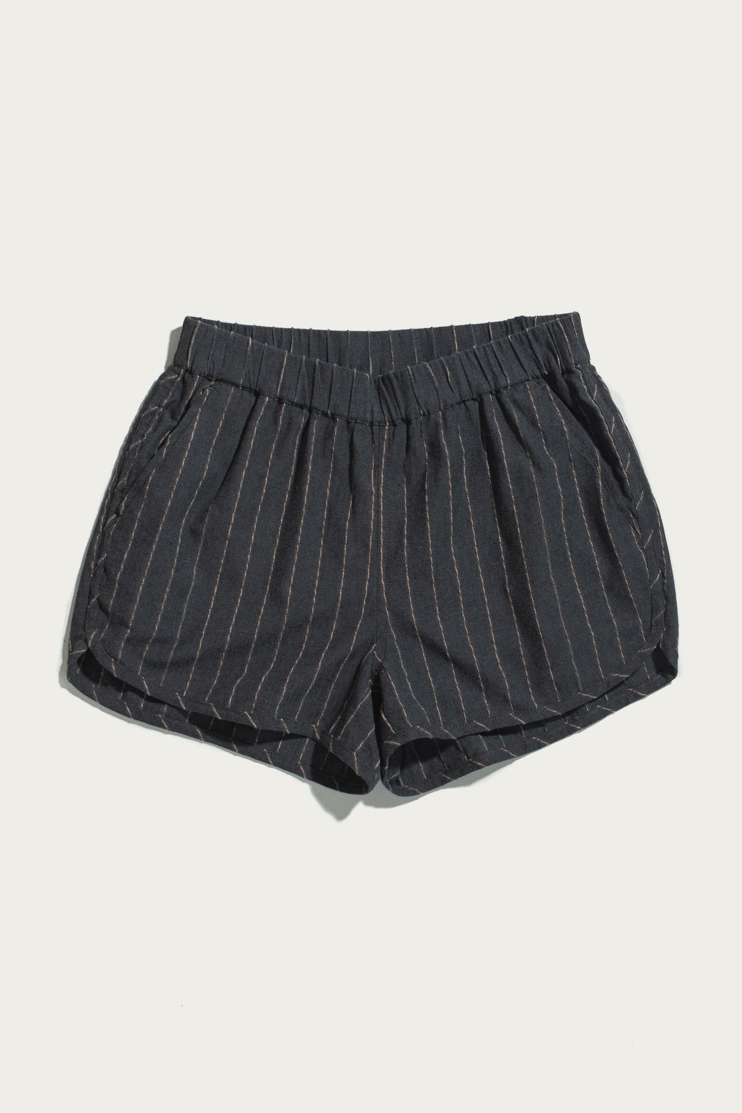 The Luca Track Short in Charcoal Stripe by Bridge & Burn is shown on a plain white background. Featuring light vertical pinstripes, an elastic waistband, and side pockets, these breathable cotton-linen blend shorts combine comfort and style—perfect for warm-weather days.