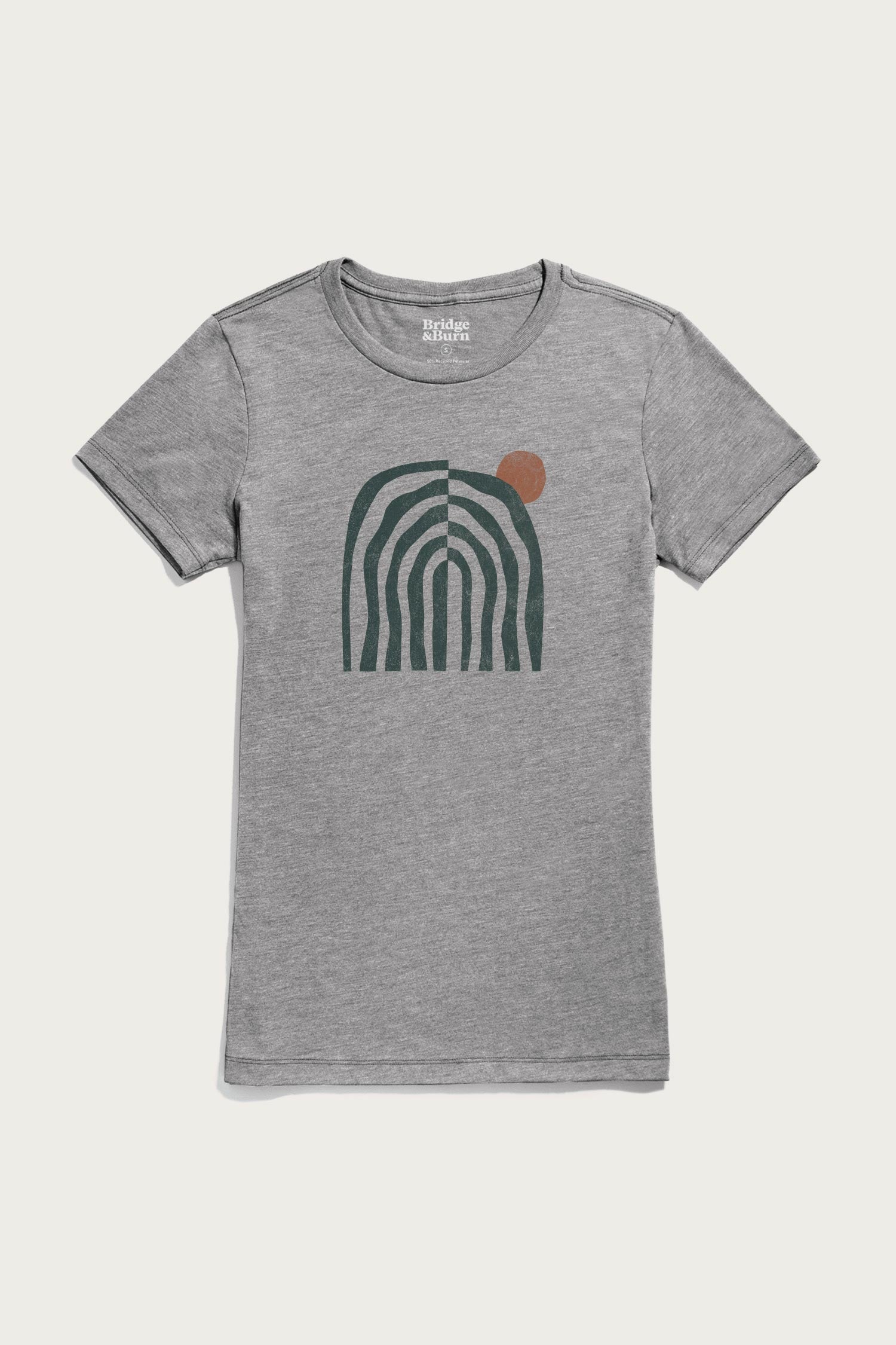 The Bridge & Burn Women's Canopy Tee in grey features an abstract design with dark green curved lines forming an arch and a small rust circle in the upper right. Lightweight and stylish, it's perfect for any casual look.