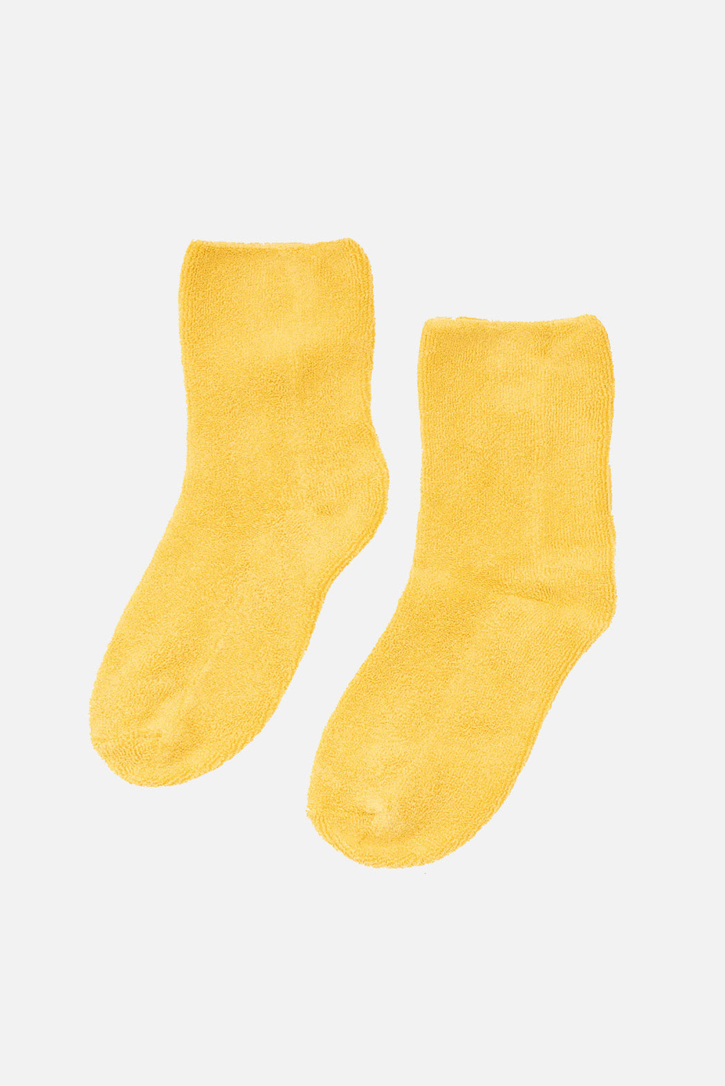 A pair of Le Bon Cloud Socks in Honey, crafted from US-grown cotton, is laid flat on a white background.