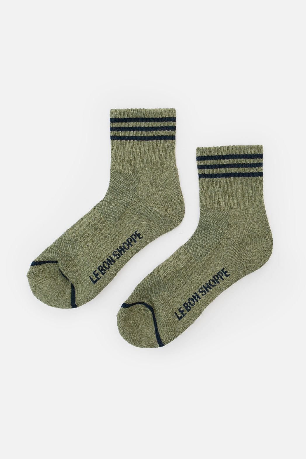 A pair of Le Bon Shoppe - Girlfriend Socks in Sage, featuring two dark green stripes at the cuffs and “LE BON SHOPPE” printed on the soles, displayed against a white background.