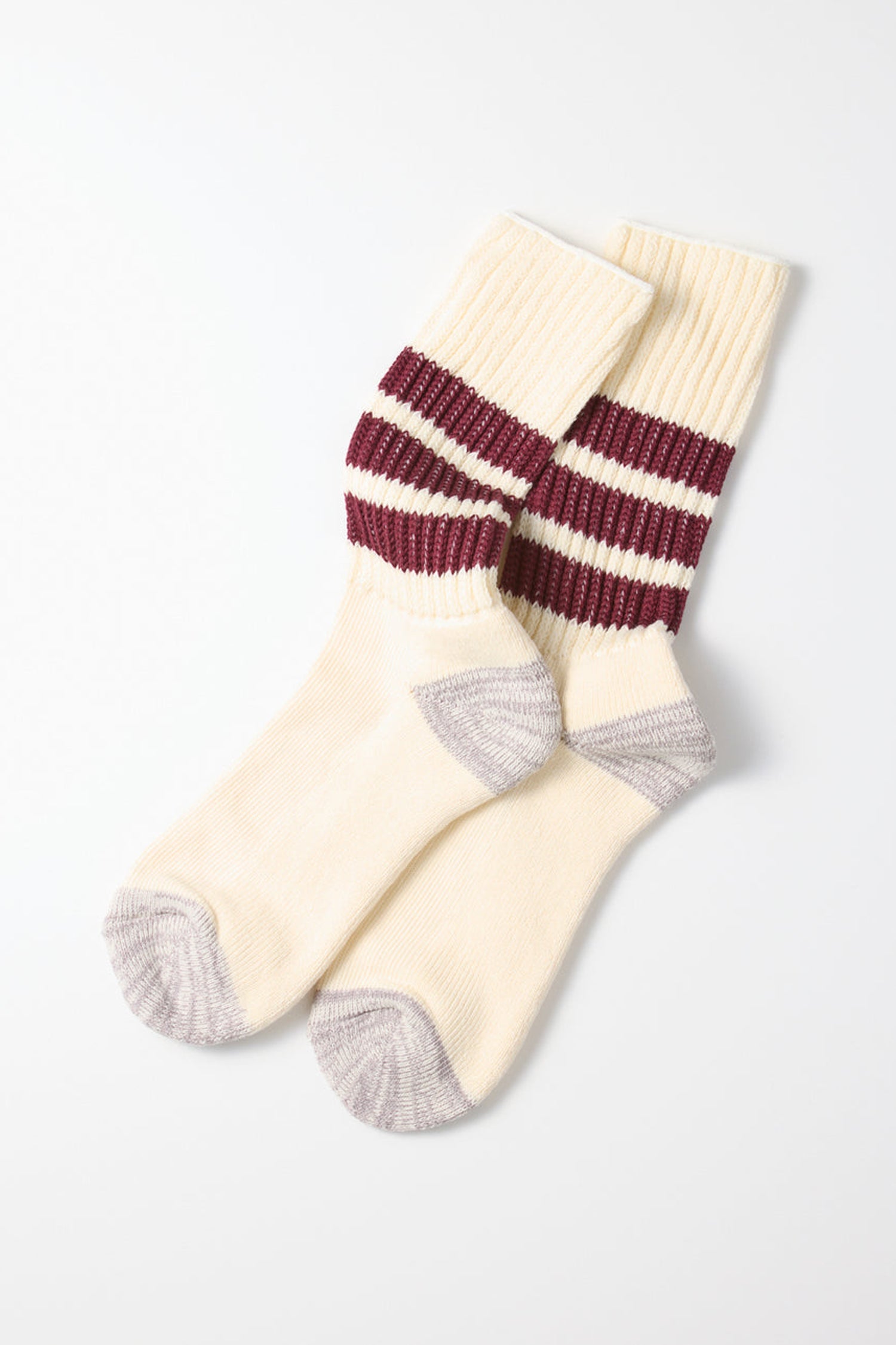 A pair of RoToTo Coarse Ribbed Old School Socks in Bordeaux, cream-colored with thick maroon stripes around the calf and gray heels and toes, laid overlapping on a white background.
