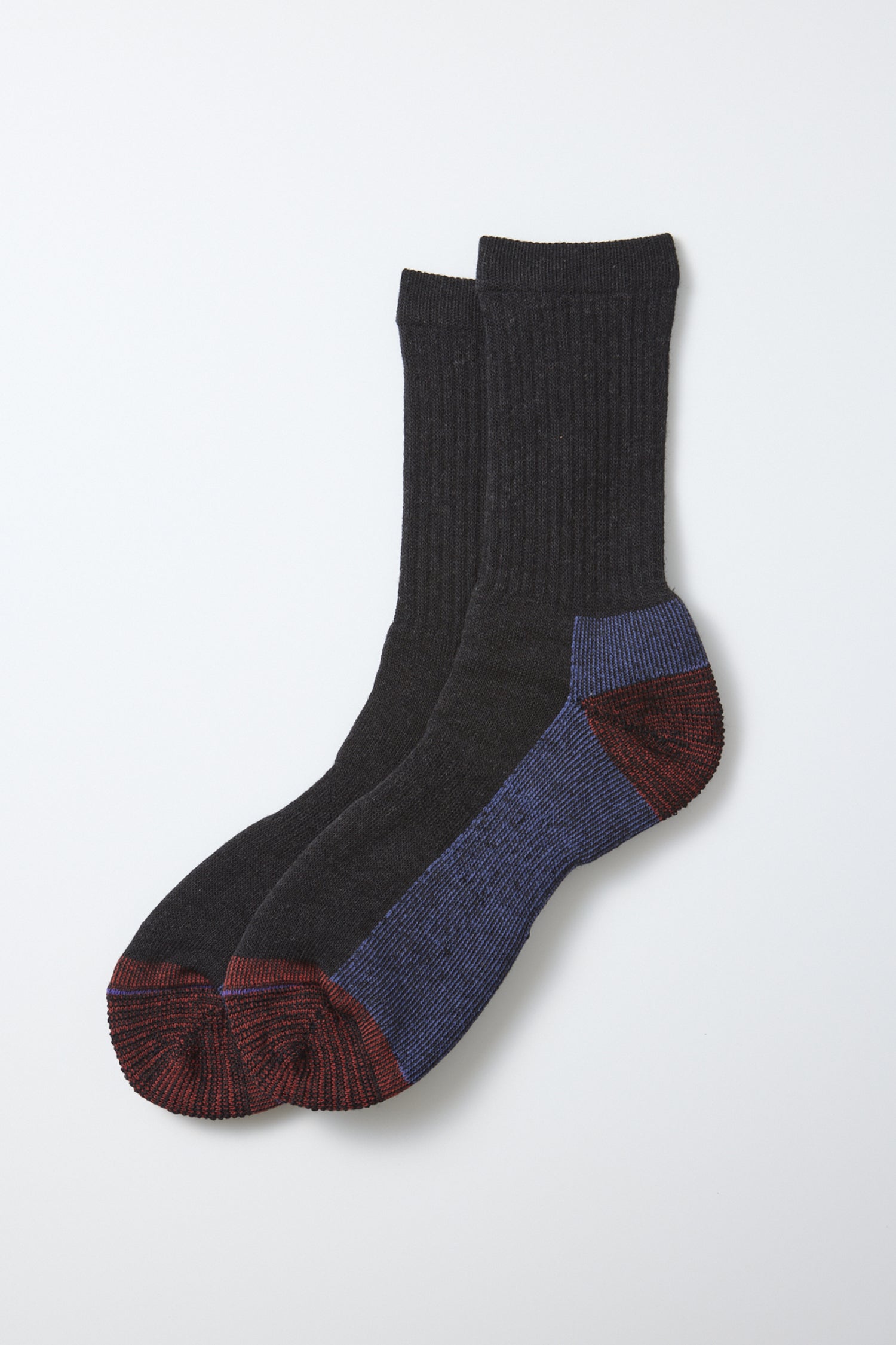 A pair of RoToTo Double Face Merino Pile Socks in Charcoal, featuring a dark gray ribbed merino wool design with red toes and heels, blue accents on the heels and soles, crafted in Japan by RoToTo and displayed against a white background.