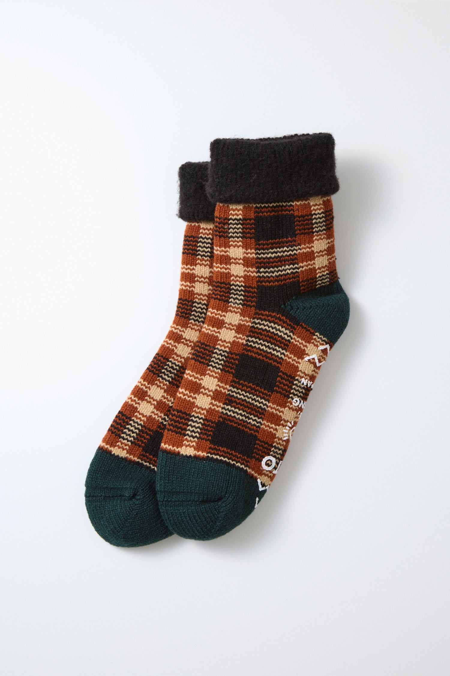 A pair of RoToTo Comfy Room Check Socks in Black Brown, featuring a comfortable plaid pattern in brown, tan, and black with dark green toes and heels and dark cuffs, made in Japan by RoToTo and displayed on a white background.