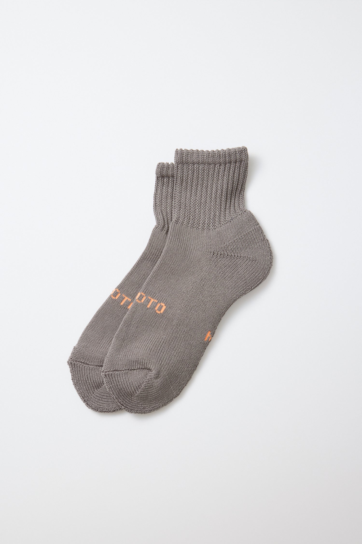 A pair of RoToTo Everyday Pile Ankle Socks in dark gray, made in Japan with ribbed cuffs and subtle orange text on the sides by RoToTo, displayed on a plain white background.