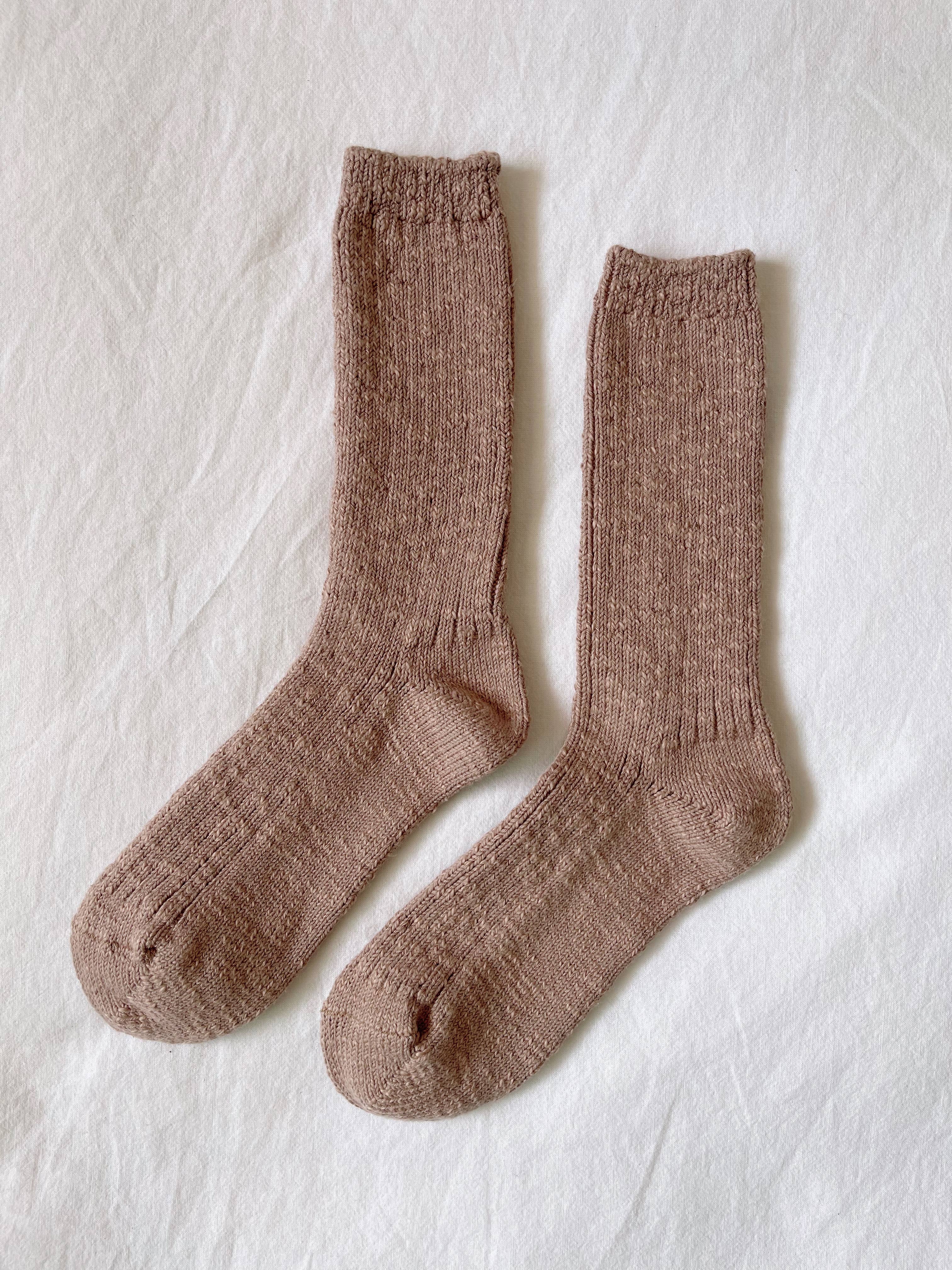 A pair of Le Bon Shoppe - Cottage Socks in Toffee is laid flat side by side on a white fabric background.
