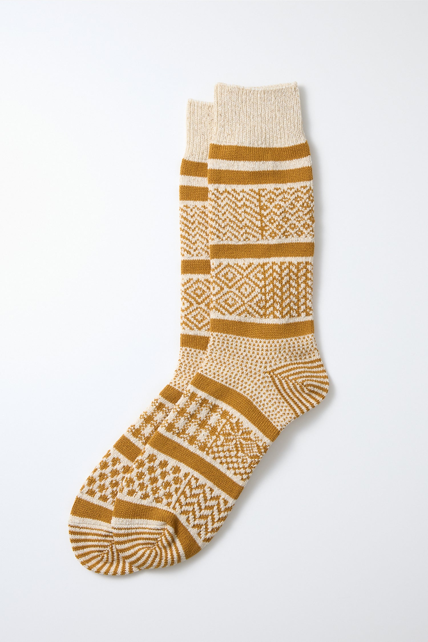 A pair of RoToTo Multi Jacquard Socks in Ivory Gold, featuring geometric and striped patterns, laid flat on a white background.