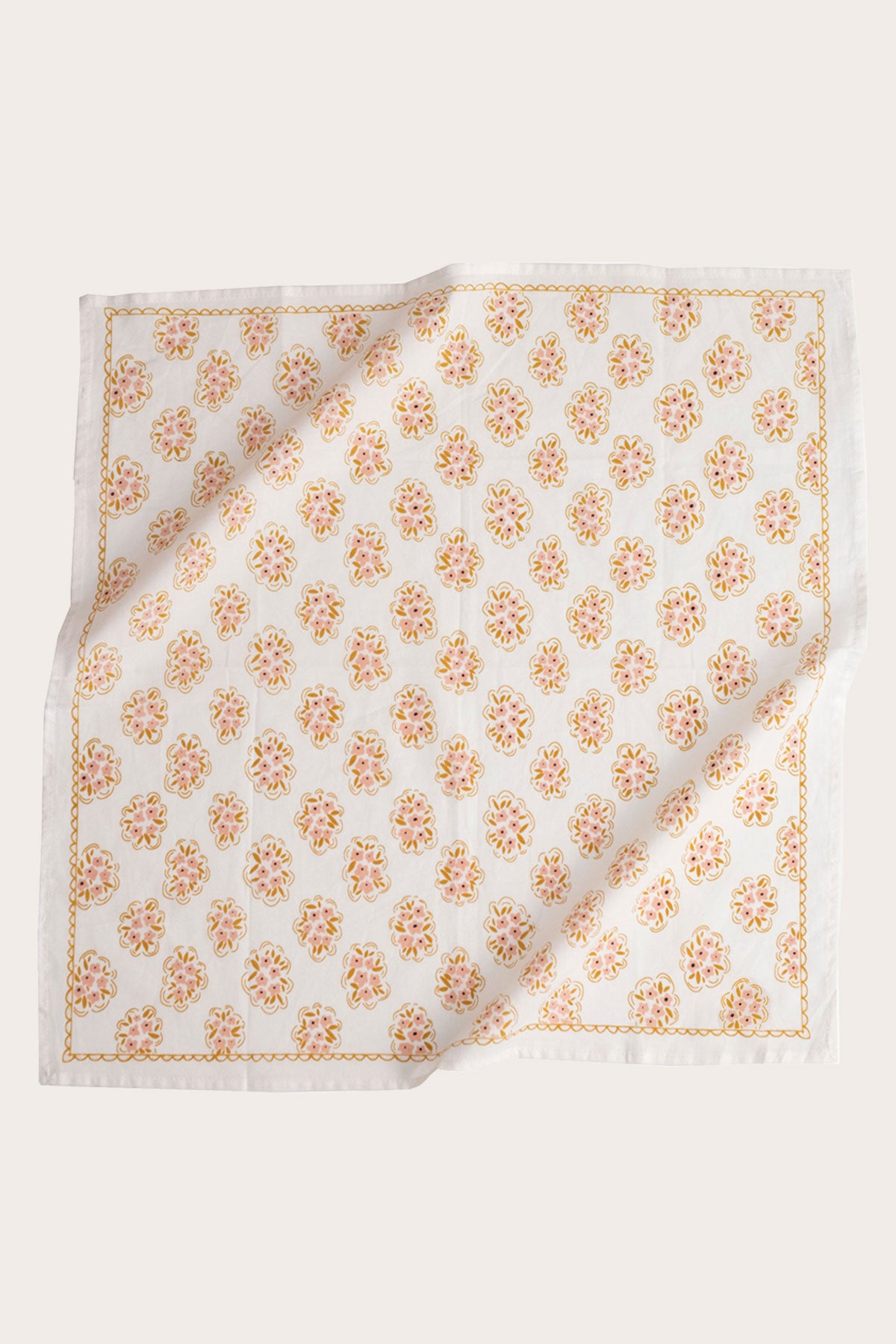 The Handker Bandanas - No. 042 Pearl Bandana by Handker Bandanas is a white cotton bandana napkin with a repeating yellow and pink floral pattern and matching trim, shown slightly rumpled on a light background.