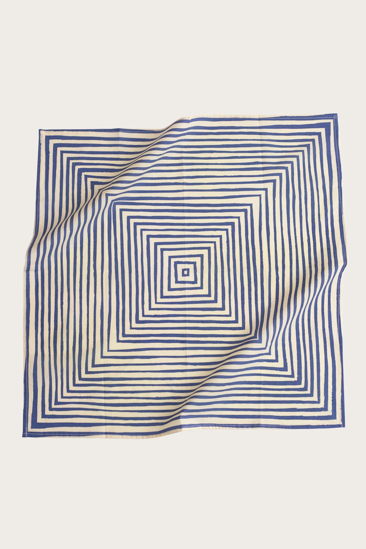 The Handker Bandanas - No. 015 Sammie Bandana by Handker Bandanas is a 22x22-inch cotton bandana with a white background and hypnotic concentric blue squares; it features a gently wrinkled look and one folded corner.