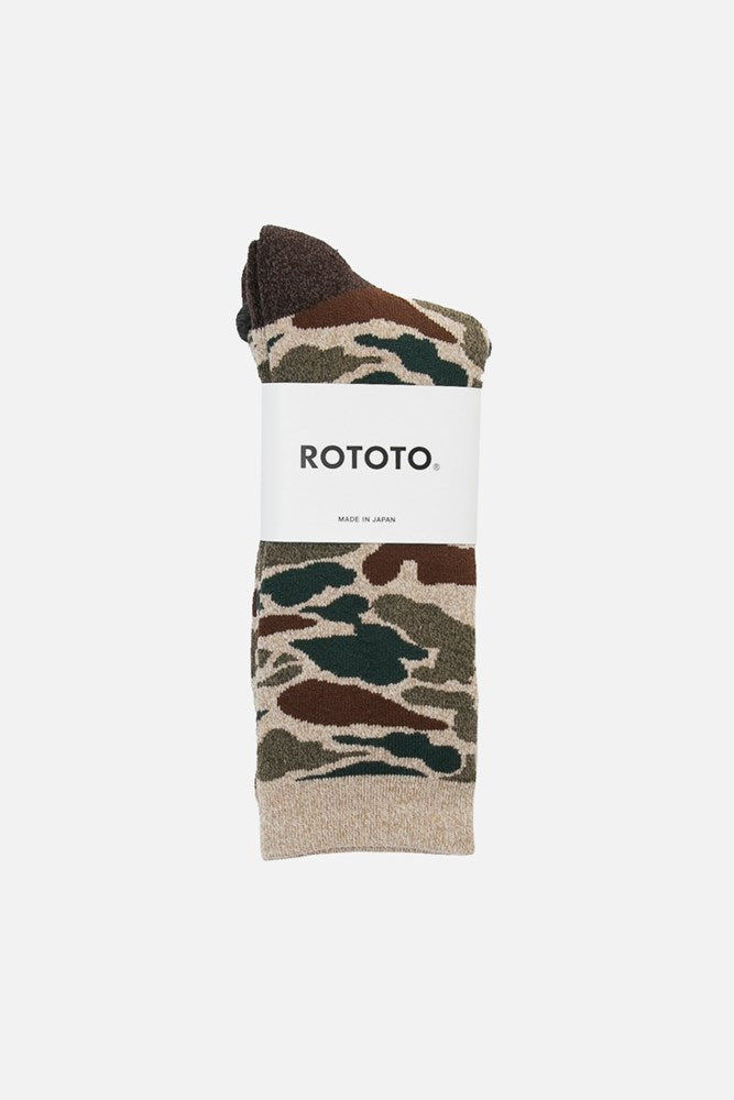 The RoToTo Pile Camo Socks in beige feature a comfy camo pattern of green, brown, and beige, folded with a white label displaying the RoToTo brand. Expertly crafted in Japan.