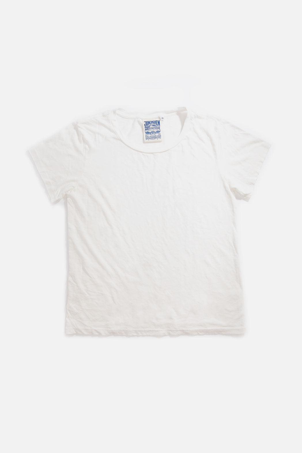 The Jungmaven Ojai Tee in Washed White, a unisex shirt made from an organic cotton and hemp blend, is laid flat on a white background with a visible blue and white Jungmaven tag at the neckline.